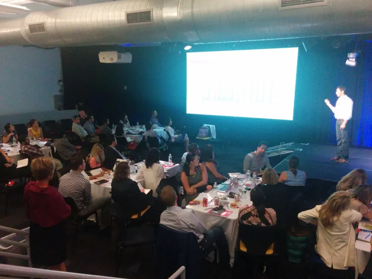 David speaking on stage at a conference event